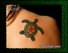 A tattoo design of a green sea turtle with an orange hibiscus flower on its shell, shown on a person's shoulder. The image has a decorative green border and the text 'LuckyFish.