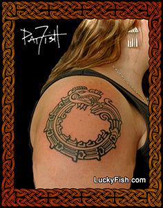 Person with a Aztec quetzalcoatl tattoo on their shoulder, with 'LuckyFish.com' branding.