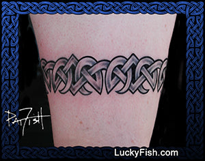 Celtic knot armband tattoo on a person's arm with 'LuckyFish.com' branding.