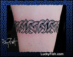 Celtic knot armband tattoo on a person's arm with 'LuckyFish.com' branding.