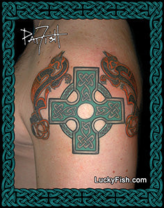 Tattoo of a green Celtic cross with red zoomorphic Celtic cat designs on a person's arm, branded Lucky Fish.