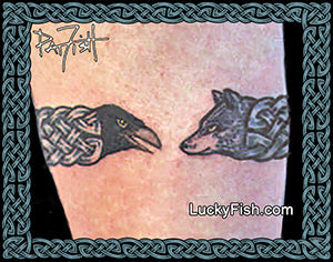 A close-up of arm showing two tattoo designs facing each other: a black  raven head on the left and a wolf head on the right, connected  with a Celtic knotwork armband. The image has a decorative Celtic border, Pat Fish signature in the top left, and LuckyFish branding.
