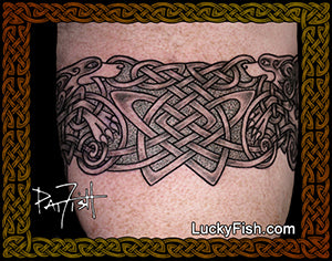 Celtic knot tattoo armband of dogs and knots on a person's arm with 'Lucky Fish' branding.