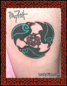 Tattoo of three ravens with a Celtic heart and triquetra in the center on a person's arm, framed with Celtic knotwork and 'Lucky Fish' branding.