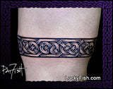 Tattoo of a Celtic knot design on a person's arm with 'Lucky Fish' branding.