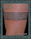 Tattoo of a Celtic knot armband design on skin with Lucky Fish branding.