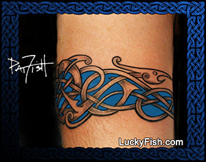 Tattoo of a Viking Nordic dragon design on a person's arm, with 'Lucky Fish' branding
