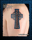 Celtic cross tattoo by Pat Fish on a person's shoulder with 'Lucky Fish' branding.